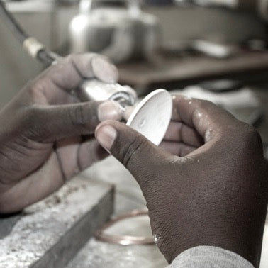 Artisan handcrafting natural ostrich eggshell jewellery in a South African studio using traditional techniques.